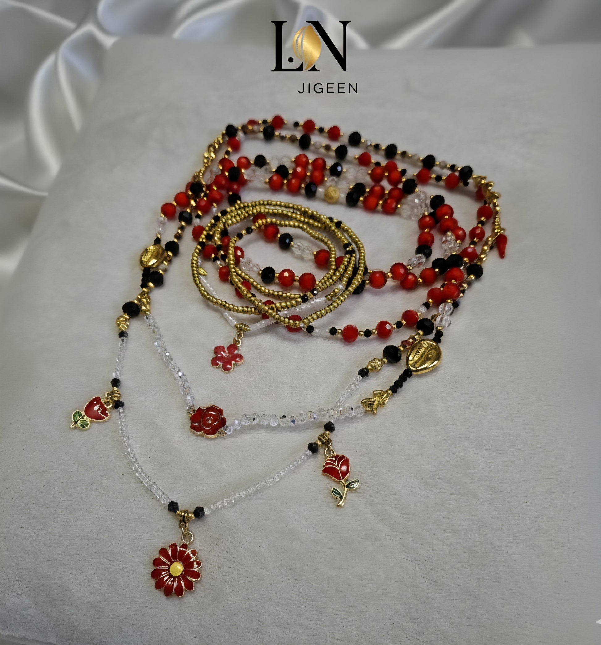 Perles de hanche traditionnelles et modernes LN JIGEEN. Création artisanale de luxe en perles rouges, noires et transparentes, entremêlées de chaînes et breloques en or fin. Ensemble de perles de corps multi-rangs, travaillées avec finesse pour un style élégant et culturel