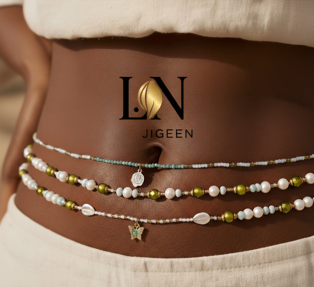 Gros plan extrême et professionnel sur trois rangées de perles de hanche Bahia portées par une femme africaine. Le zoom accentué met en évidence les détails complexes du bijou, y compris les perles de couleur vert olive, blanche et turquoise, la breloque papillon, les coquilles et une rose délicate. Image de produit haute résolution pour la vente en ligne de bijoux de taille traditionnels.