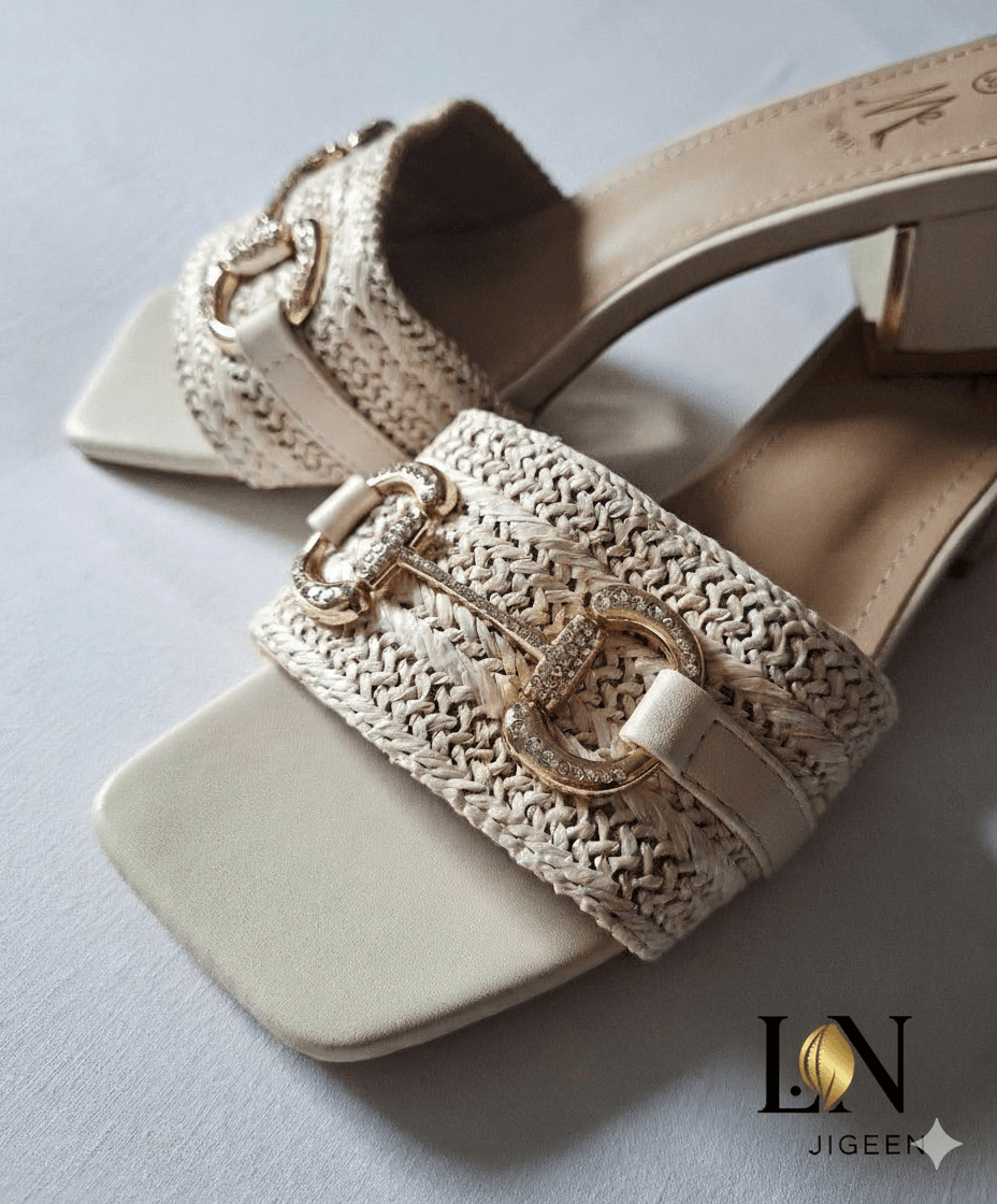 [
  {
    "code": "image-seo-reference-code",
    "alt_text_fr": "Une paire de mules beiges de la marque Jigeen, avec une lanière en paille tressée et une boucle dorée ornée de strass.",
    "alt_text_en": "A pair of beige mules from the Jigeen brand, with a braided straw strap and a gold buckle adorned with rhinestones.",
    "file_name": "mules-amelia-jigeen-gros-plan.jpg",
    "title_fr": "Mules Amélia Jigeen gros plan",
    "title_en": "Amelia Mules Jigeen close-up"
  }
]

