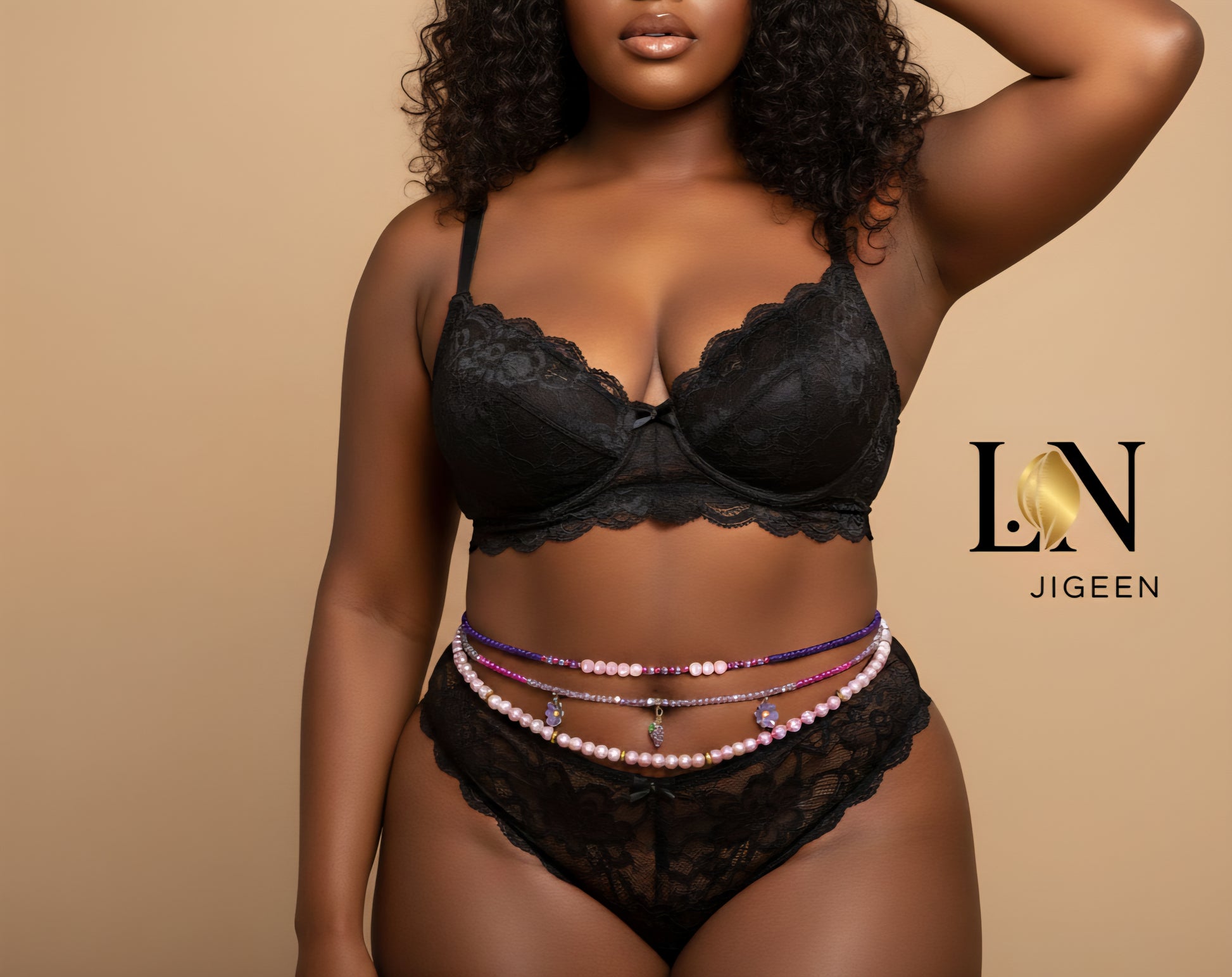 Gros plan sur une femme noire aux formes généreuses, vêtue d'une lingerie en dentelle noire. Elle porte trois rangs de perles de taille (bijoux de corps) aux couleurs mauve et rose. Logo de la marque "LN JIGEEN" centré au-dessus des perles.