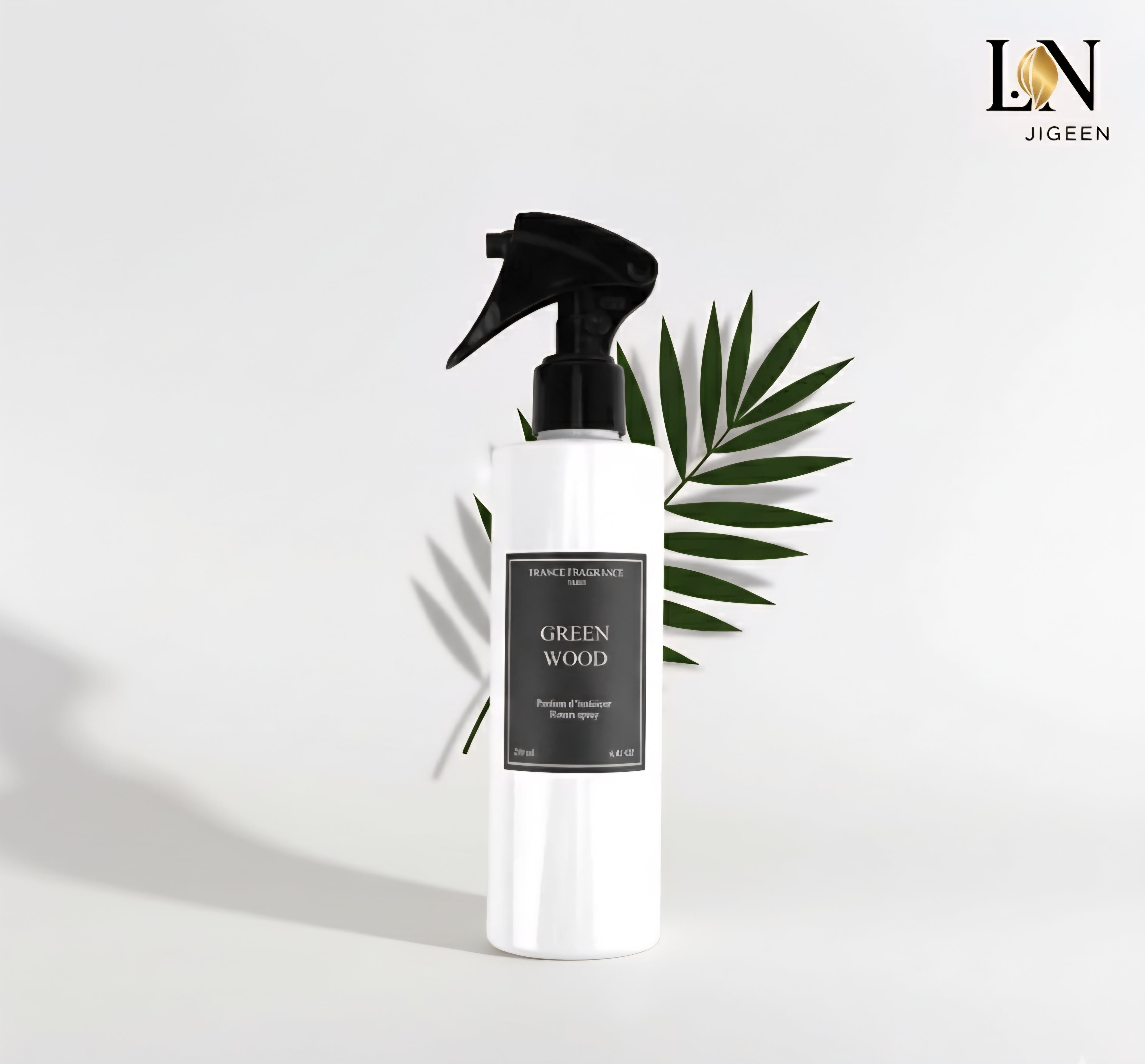 Spray d'intérieur Green Wood de France Fragrance, sur une table en bois, avec des feuilles et morceaux d'écorce. Photo professionnelle avec logo Jigeen en haut à droite.