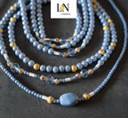 Gros plan détaillé des perles de hanche 'LN JIGEEN' montrant les perles bleu pastel, les perles dorées à facettes et les perles de cristal transparent. La netteté de l'image met en évidence la texture et la qualité des matériaux, essentiel pour la revente de ce bijou de taille.